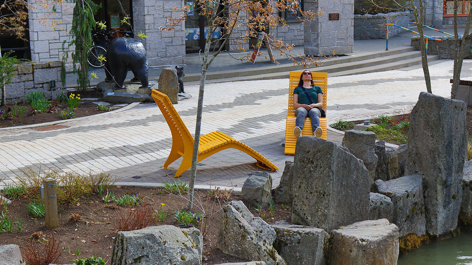 Women sitting on Yellow Chaise Lounge by rocks