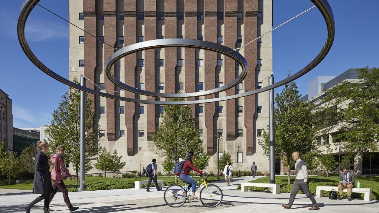 Two circles suspended in the air with students walking beneath