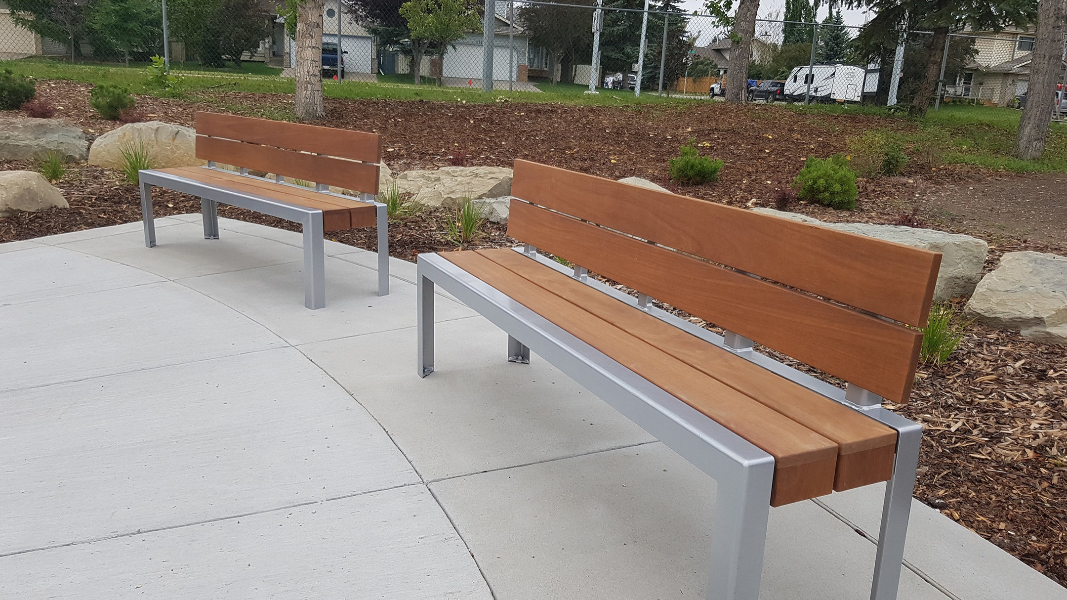 Two wood backed 1050 benches in park