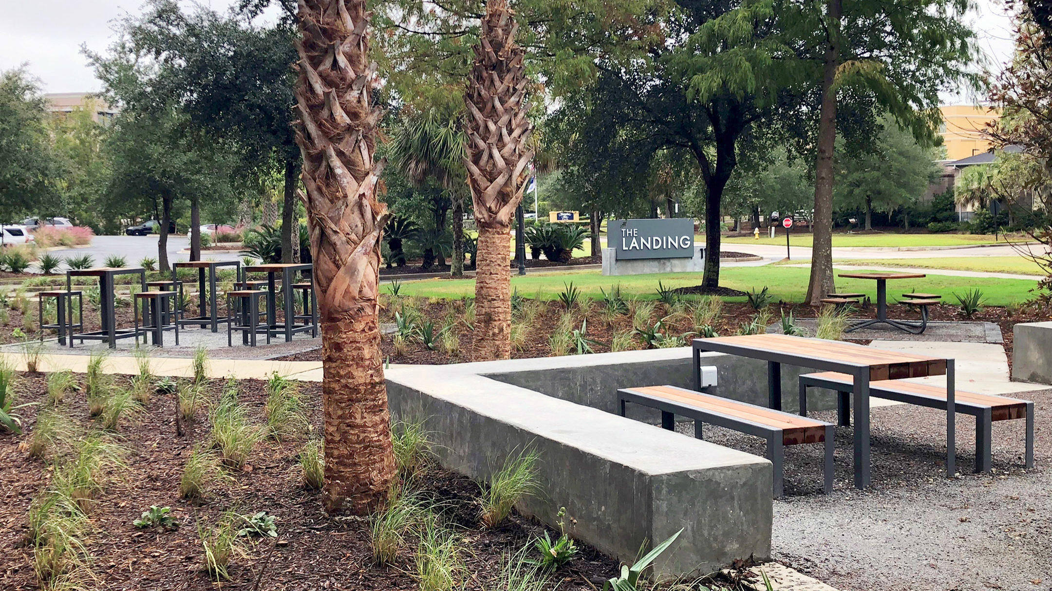 The Landing sign with tables and seating in courtyard setting