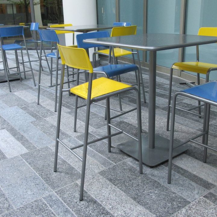 Yellow and Blue Chairs surronding a Foro Stool Table