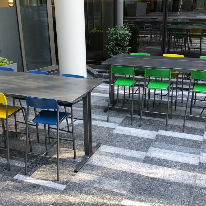 Bar height tables and brightly painted stools at Bank of America Plaza