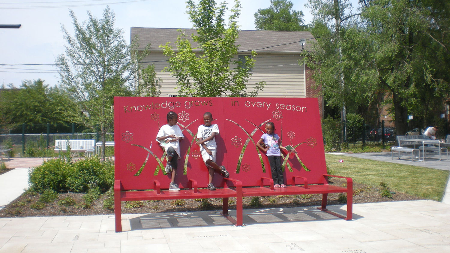 Oversized red bench with children standing on it