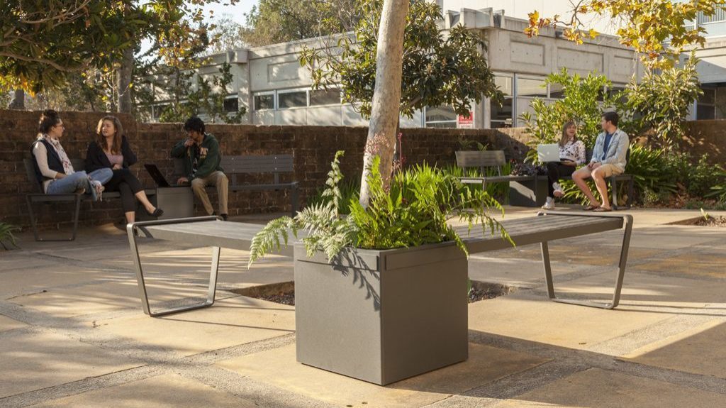 Lexicon planter and benches with students in background at CalPoly University