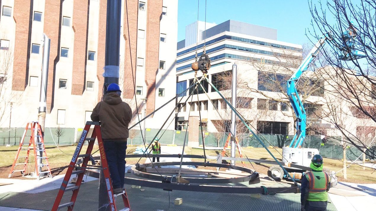 Construction workers lifting two circles into the air