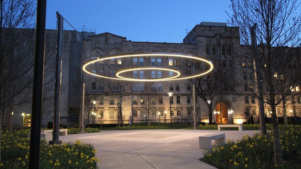 Two lit circles suspended in the air with an empty patio below