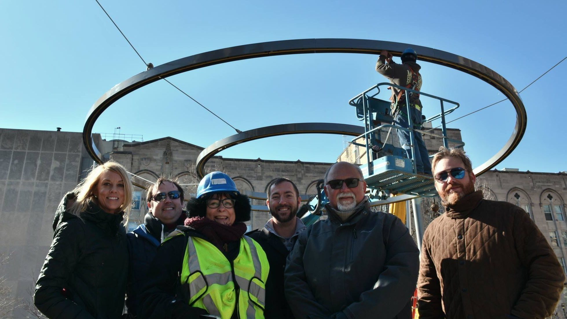 A group of people in the foreground smiling with the circle of light