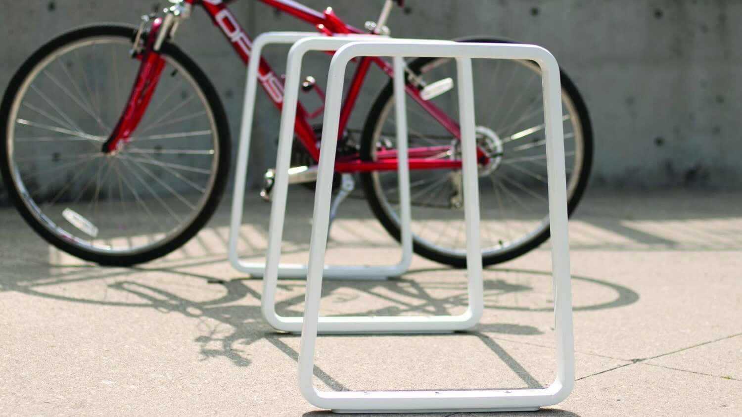 White Iconic bike rack with a red bike behind it