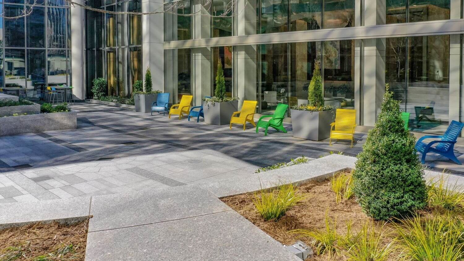 Yellow, Green and Blue patio seating outside glass building