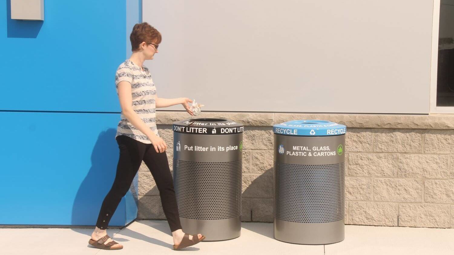 Woman throwing trash into a 600 series trash container