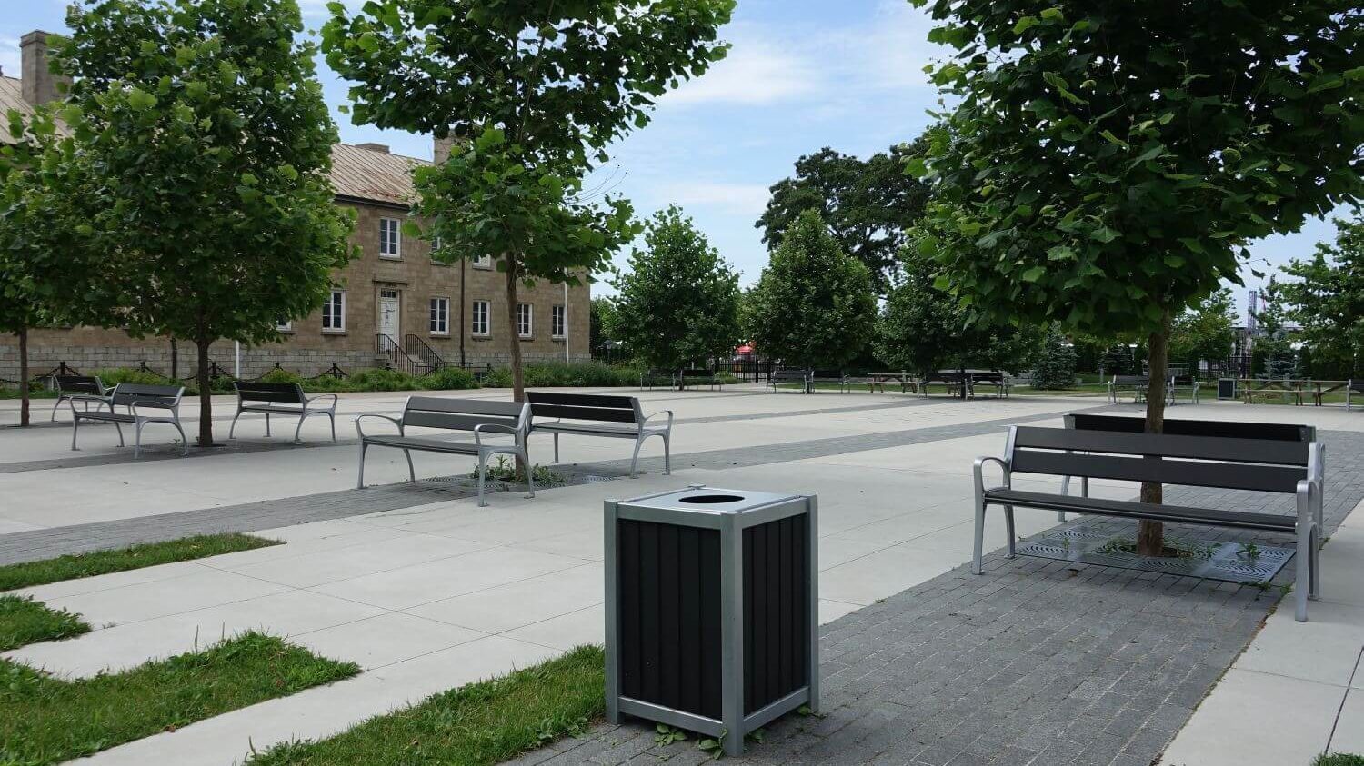 Black and Silver bin near benches and trees