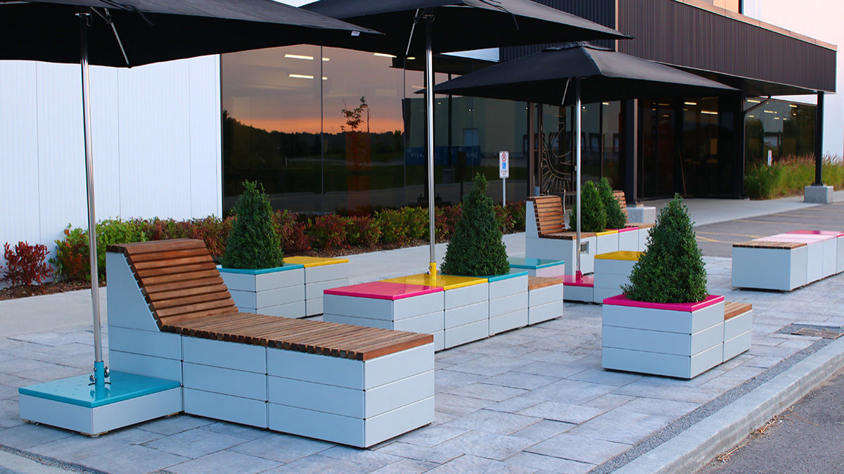 Pixel blocks with brightly painted tops and Tuuci umbrellas at Maglin Site Furniture