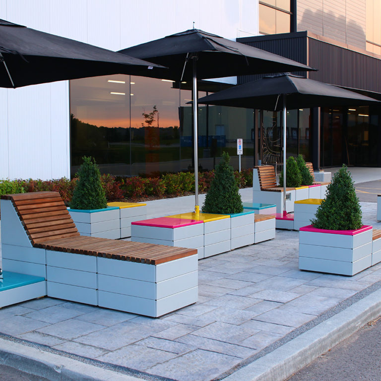 Pixel blocks with brightly painted tops and Tuuci umbrellas at Maglin Site Furniture