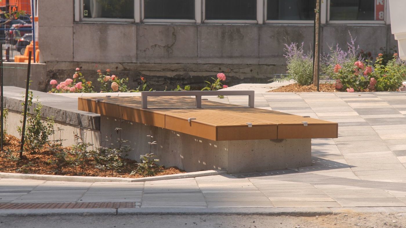 Two identical seating platforms near small flowerbed