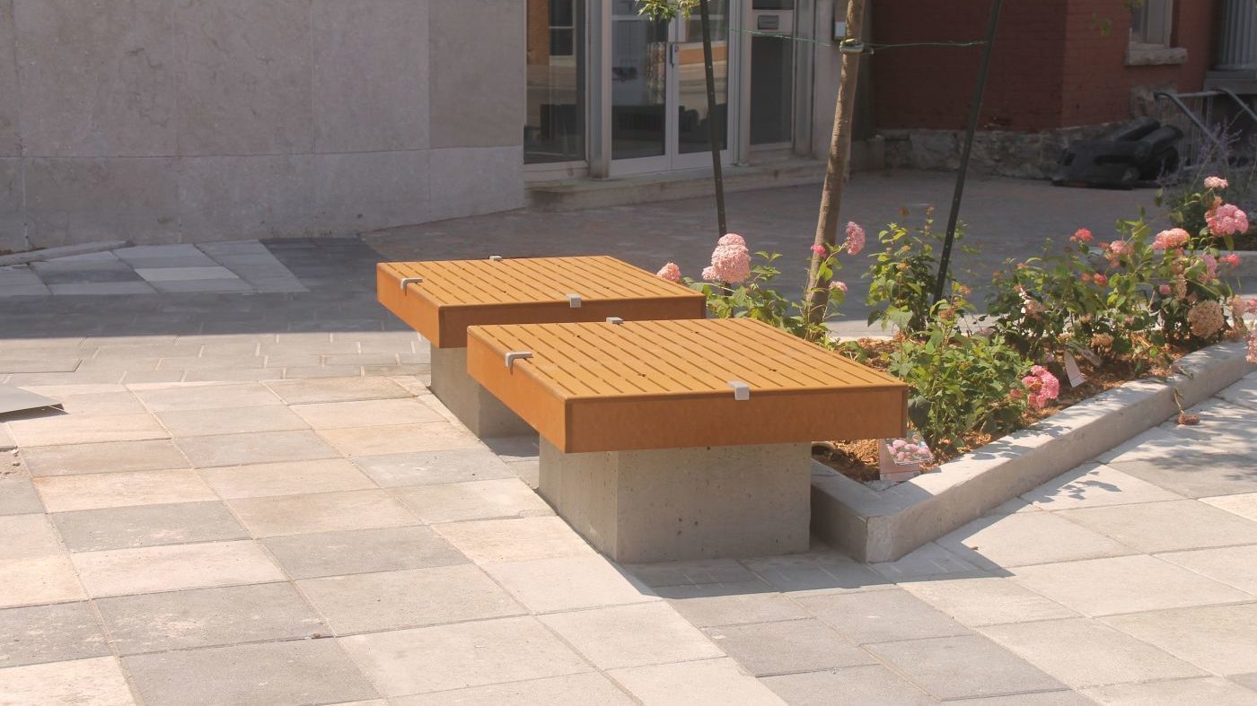 Two identical seating platforms near small flowerbed