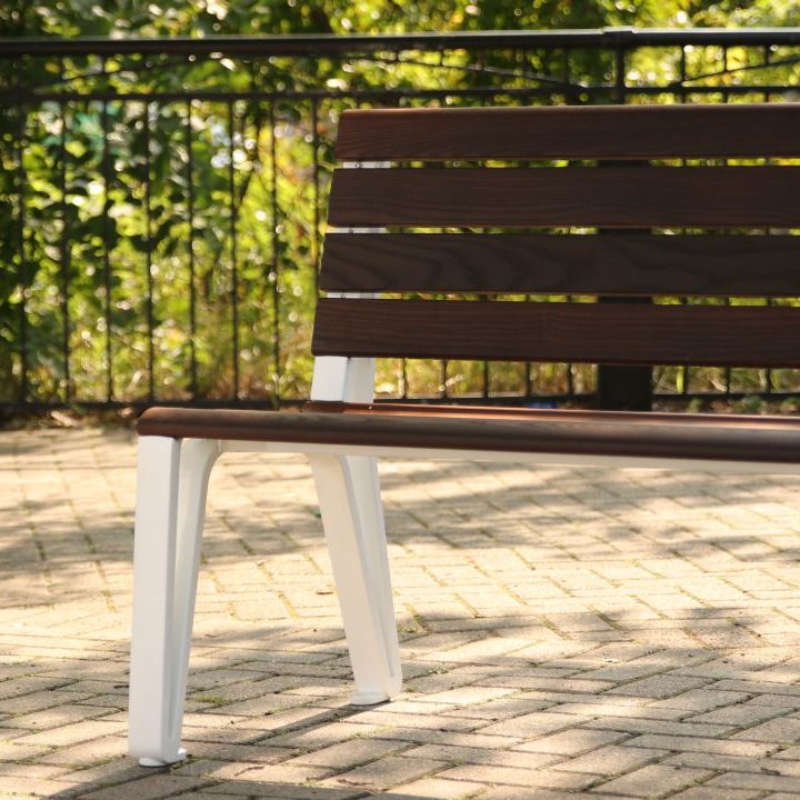 Wood bench close-up with white castings from the Iconic Collection