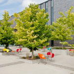 Red, Blue, Yellow and Orange chairs outside building