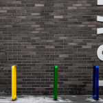 Bright Coloured Bike Racks near brick wall that says "LOVE"