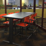 Table inside office with six orange chairs