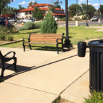 Black Trash Can and Wood Benches in Outside area