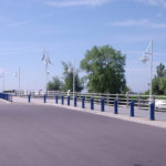 Blue sky and open road with blue bollards