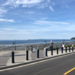 Black bollards line street with clock tower and blue skies