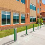 MUG Bike Racks painted gloss green and gunmetal in front of school  building