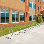 100 Series - 150 Bike Rack lined up in front of school building on bright day