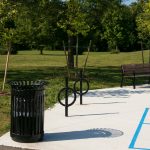 200 Series Trash Receptacle with bike racks and Iconic bench at park