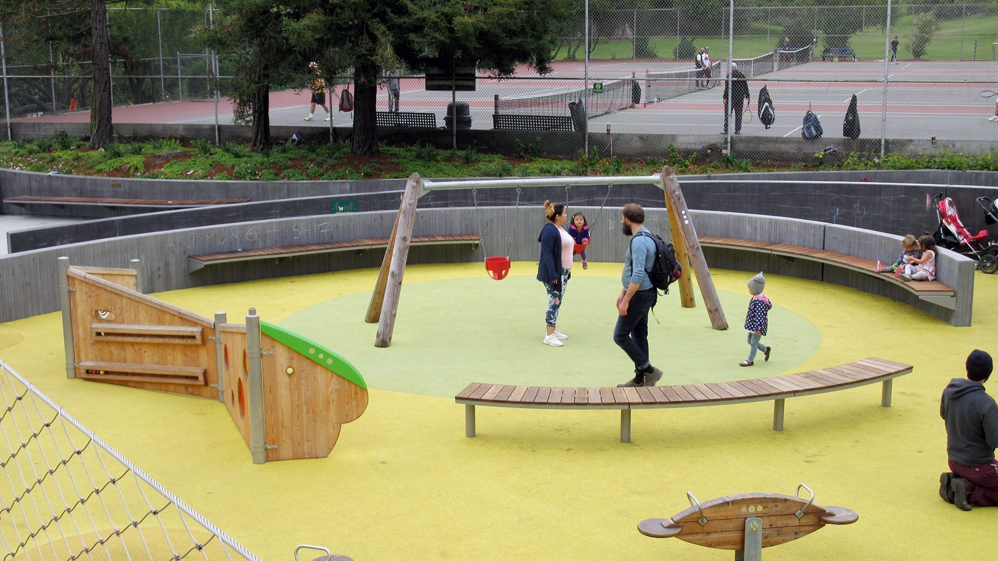 Overhead view of a playground with cantilever and pedestal mount backless wood Ogden benches and wooden playground equipment.