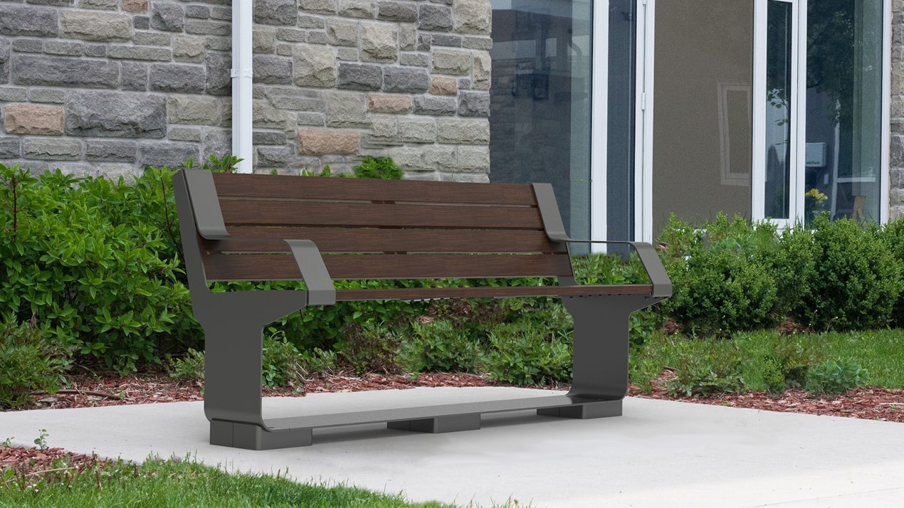 L-Series Backed Bench next to greenery and building