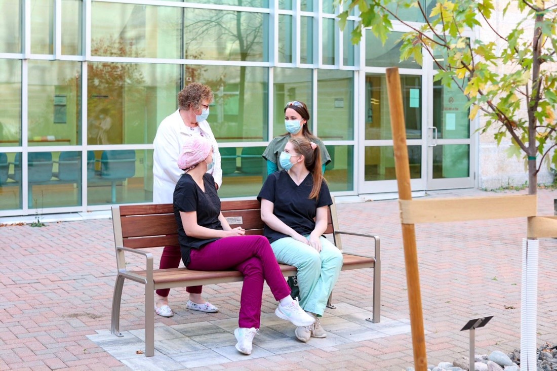 Healthcare workers sit on a bench provided by Maglin and One Bench One Tree at Thunder Bay Regional Health Science Centre