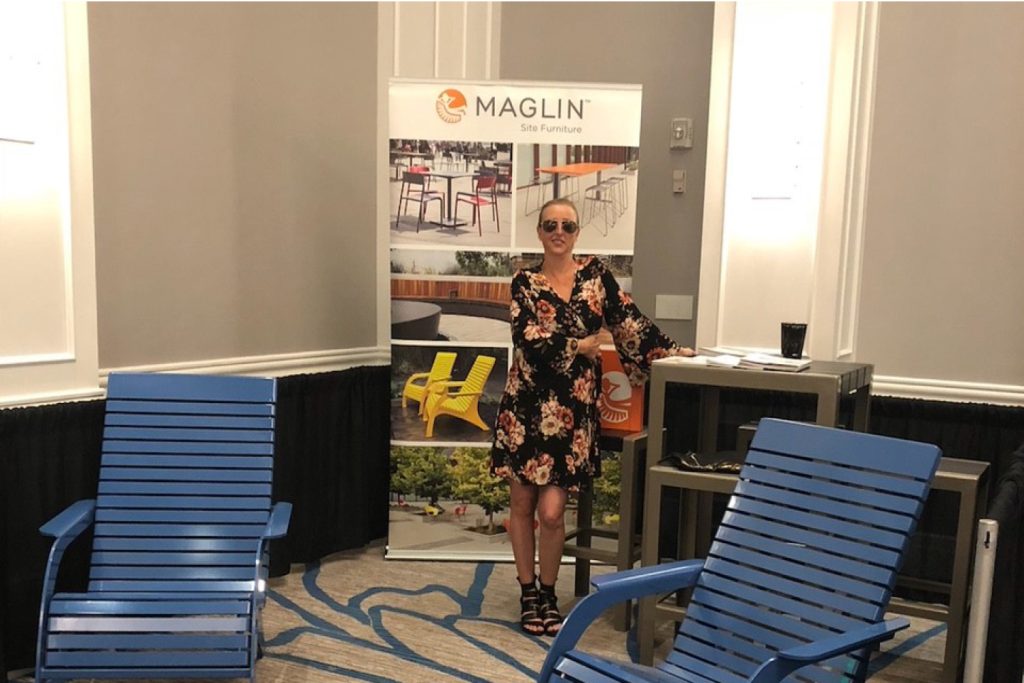 Jenn posing at a tradeshow next to some 720 chairs and a 1050 table