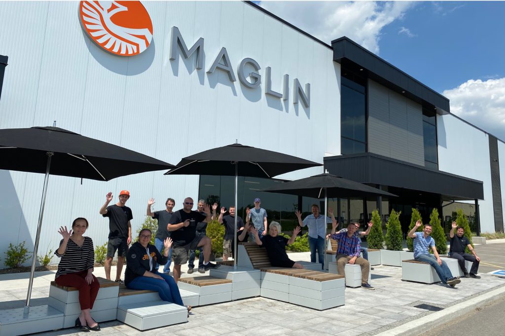 Maglin team waving outside the head office on a sunny day