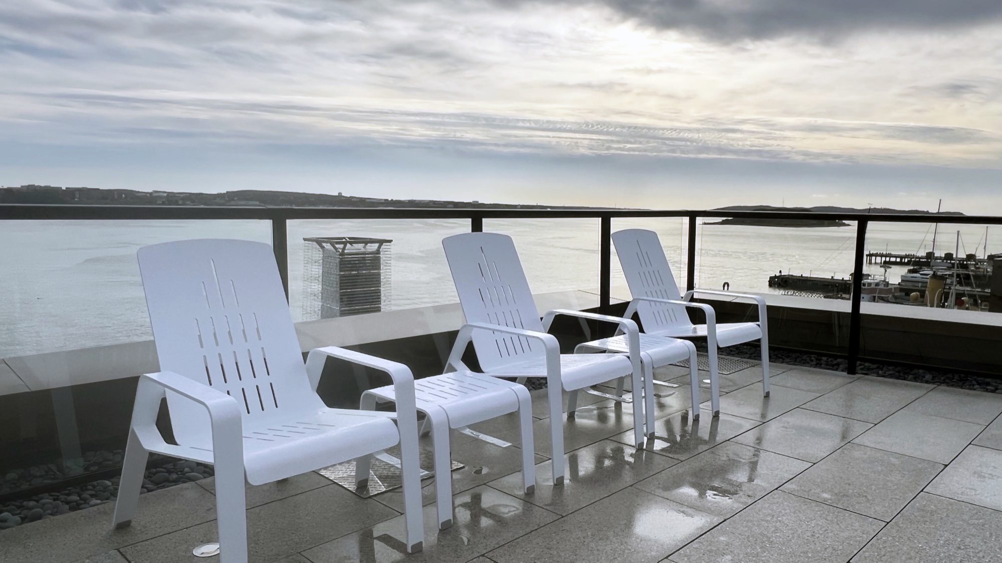 Set of 3 white Alum lounge chairs with lounge tables on the rooftop of Stewart McKelvey in Halifax.