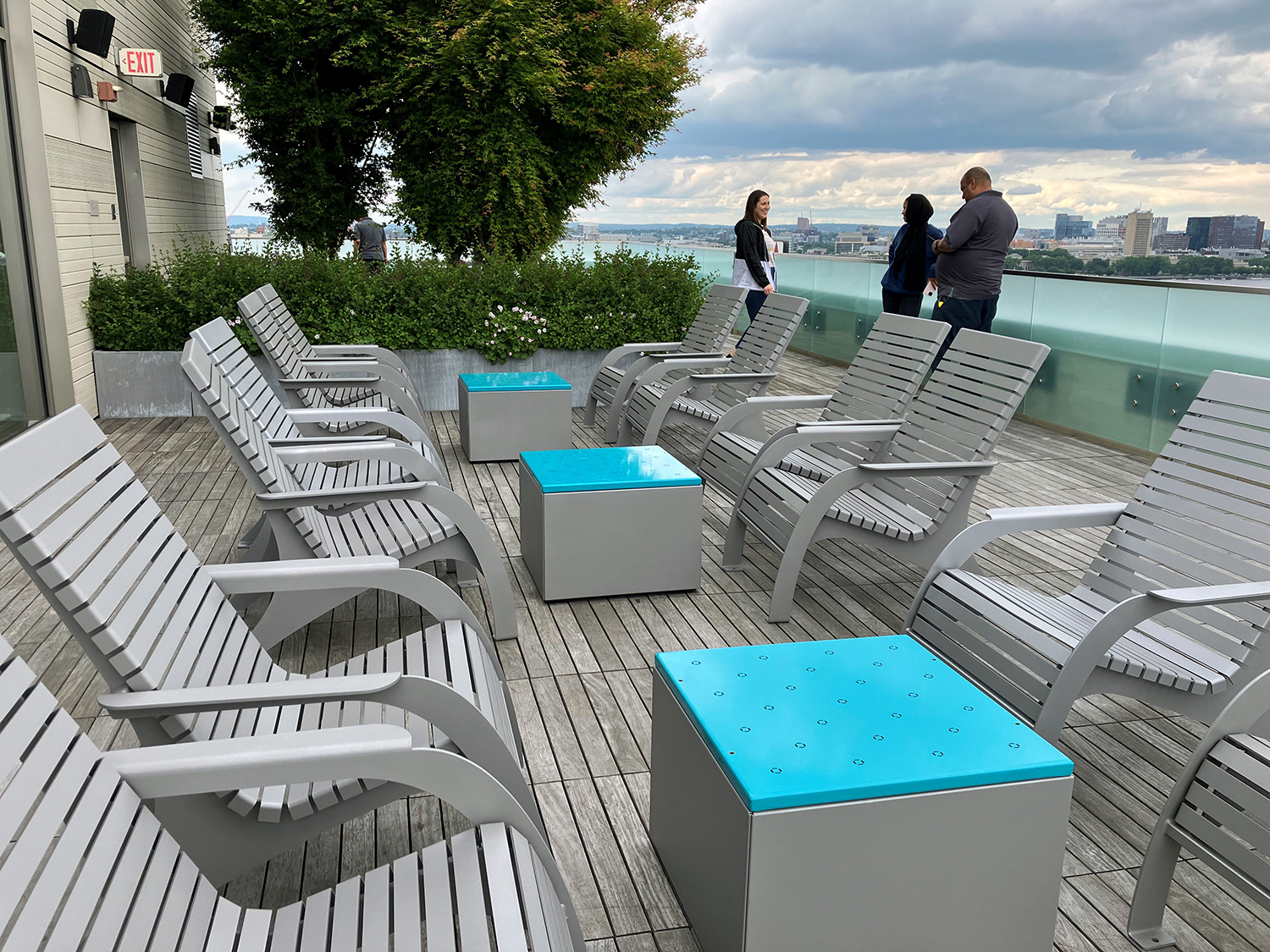 720 Chairs with Pixel Block cocktail tables in the foreground, people in the background enjoying the view at Viridian Apartments in Boston.