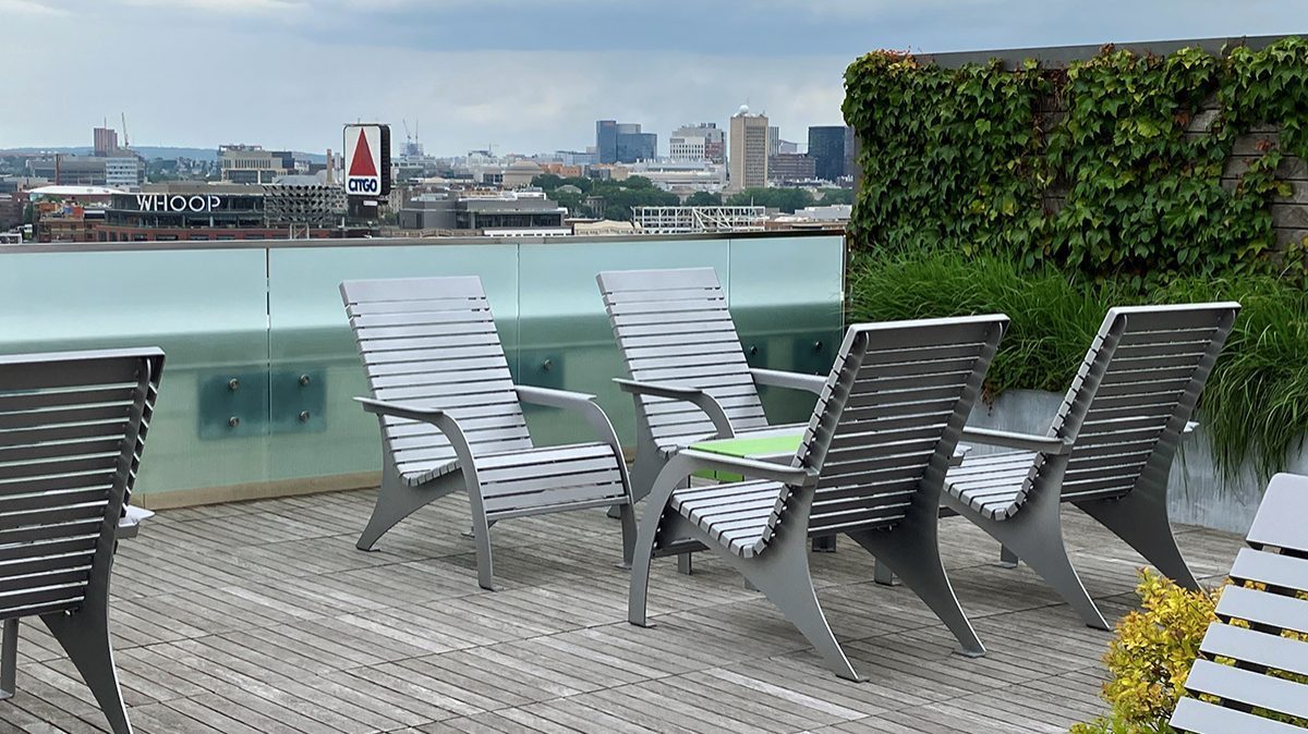 A group of four 720 chairs face each other with a 1050 short bench as a cocktail table on the roof deck of Viridian Apartments.