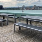 1050 Standard Tables with Backless Benches on rooftop patio overlooking city