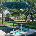 210 Cluster Seating with umbrella at park against green grass and trees