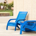 Brightly painted blue 720 Chairs with Pixel block on school campus against wall