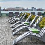 720 Metal Chaise Lounge on rooftop deck surrounded by city buildings