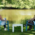 ALUM Collection lounge chairs with lounge table powdercoat pastel blue and white with women laughing and enjoying the scenic landscape