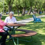 FAVA Cluster Seating with wood, quad and single seat along trail with two ladies enjoying a break