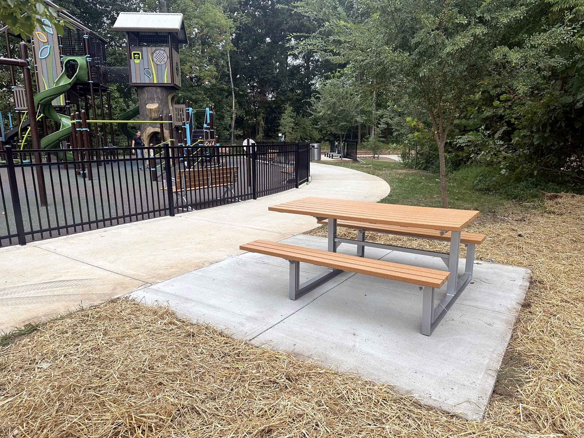 A newly installed Maglin 210 Cluster Seating picnic table with extended wheelchair accessible table top next to the playground at Rosedale Nature Park