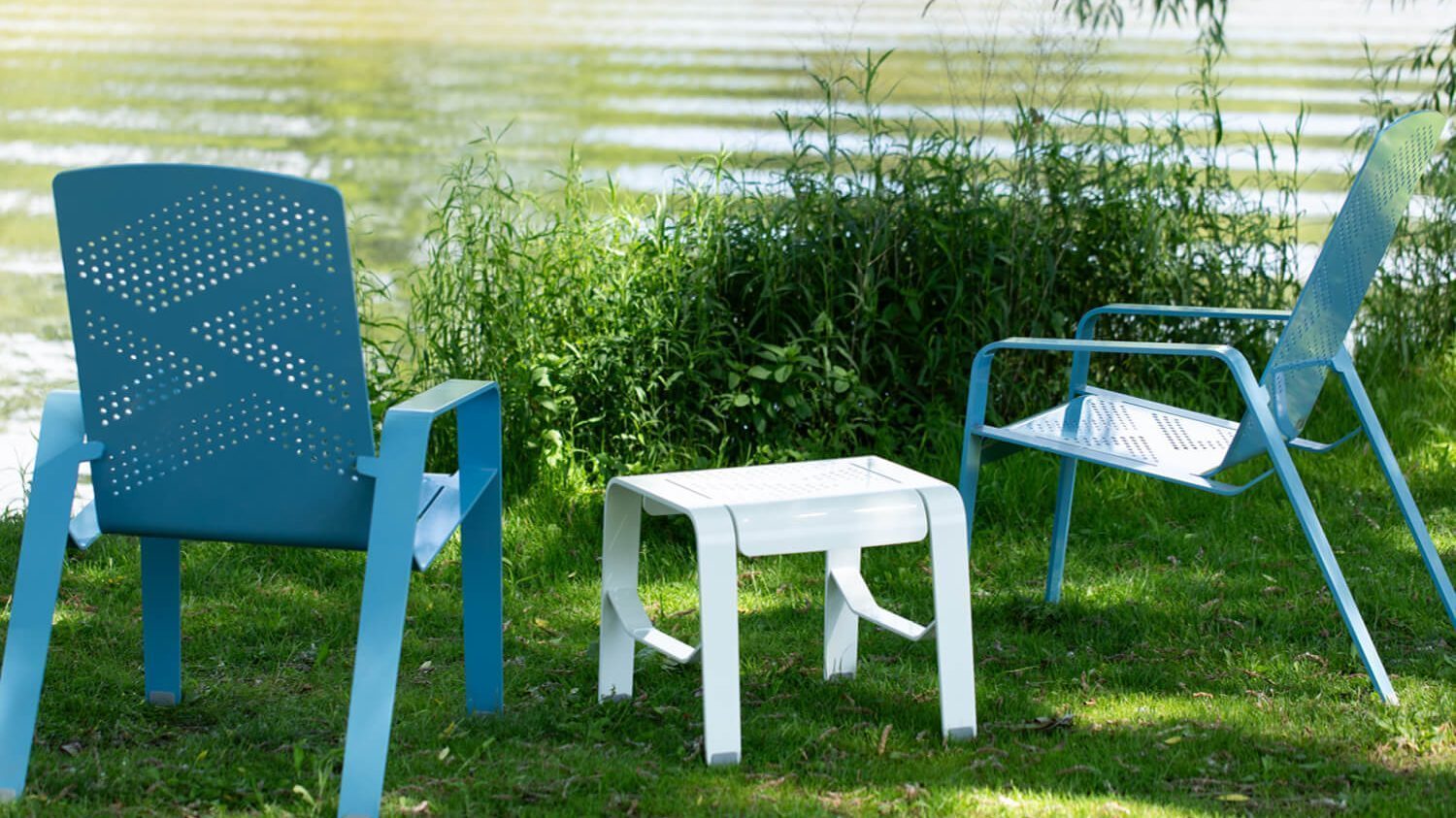 ALUM lounge chairs and footrest sitting on grass next to pond