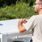 Close-up of ALUM table in white powdercoat with man smiling while seated